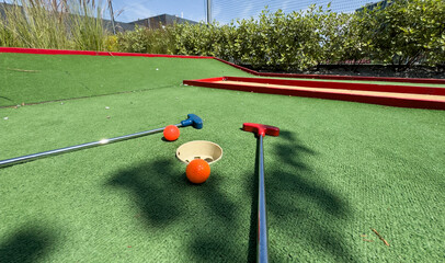 Golf stick and ball on green grass close up.