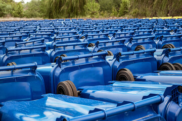 Naklejka premium rows of new municipal colored trash cans with wheels, ready to be distributed to the population