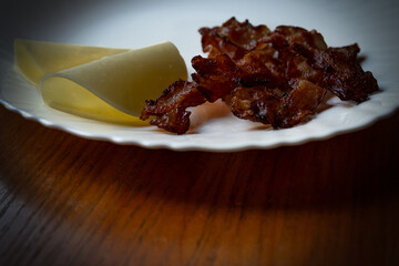 fried bacon and cheese on a plate close-up on a blurred background, food background image