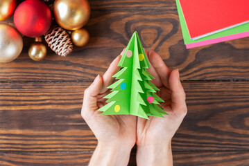 Step-by-step Christmas tree handmade paper toy. The final result of the tree made of colored paper. Top view.