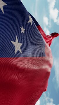 Wavy flag of Samoa blowing in the wind in slow motion. Waving official Samoan flag team symbol abstract vertical background. Blue sky with clouds. World countries flying flags concept