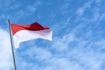 Indonesian Flag, Red and White, with blue sky background.