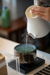 Pour hot water from the tea into the matcha bowl. A warm cup of matcha is made of finely ground green tea powder