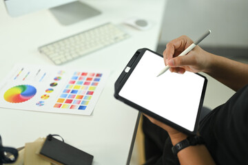 Cropped shot male designer or or creative professional using digital tablet and stylus to work on a...