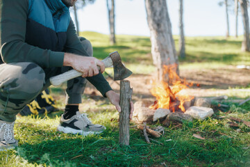 Obraz premium Wilderness Wood Chopping by Campfire, Demonstrating Survival Techniques