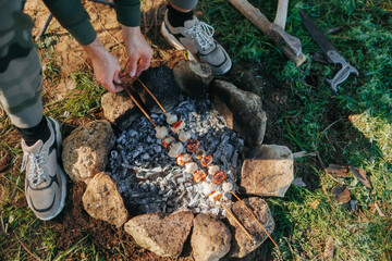 Camping Moment Roasting mushrooms and sausages Over Fire in Wilderness