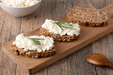 Home made rye bread on a wooden cutting board with curd cheese