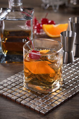 Cocktail Old Fashioned is an old-fashioned sophistication of whiskey and sweet syrup. Served with ice, orange zest and Maraschino cherry.
