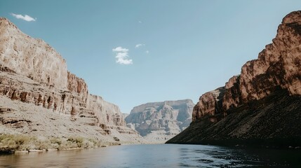 Photograph of a serene and tranquil river winding through a picturesque canyon with towering red rock walls on either side creating a dramatic and stunning natural landscape