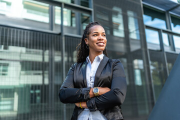 Latin modern businesswoman with long braids standing proud outside building