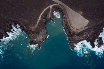 top view of foamy sea breaking over the volcanic coast of Los Hervideros in Yaiza, Lanzarote at Canary Islands, Spain, concept of wild nature