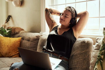 Zen woman, music headphones and laptop in home for meditation subscription in lounge to relax. Subconscious program, podcast and calm girl resting on sofa for peace, streaming radio or online channel