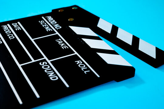 Close up of black wooden movie clapperboard on a blue background, cinematography tool concept