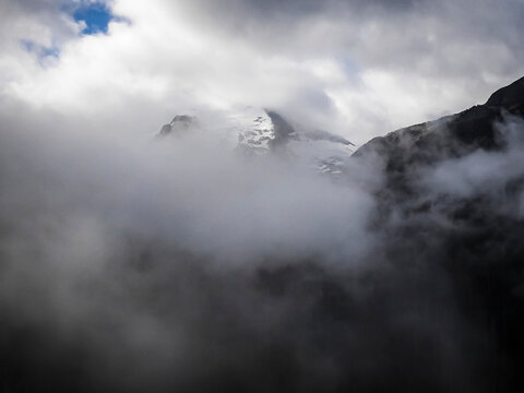 Aerial view of majestic mountains shrouded in fog and clouds, Agassiz, Canada.