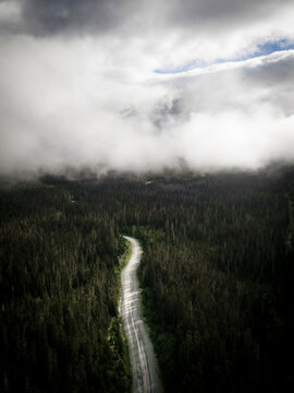 Aerial view of winding road through lush forest under cloudy sky, Agassiz, Canada.