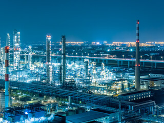 Aerial shot of refinery chemical plant industrial equipment in large industrial area at night