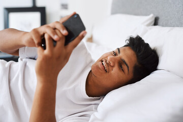 Teenager, person and smile with phone in bedroom for online communication, website and social media. Happy, boy and relax with technology at home for text message, notification and reading update