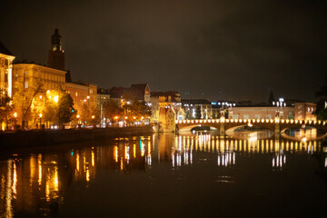 Wroclaw night city embankment with lights and bridge, 
night landscape of a city embankment with many colored lights reflected in the water