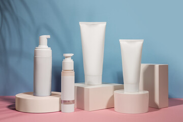 White cream tube on podium mockup on a blue background. The concept of cosmetology, body and face care