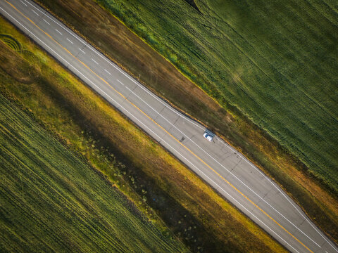 Aerial view of beautiful fields and a road with one car, Pincher Creek, Canada.