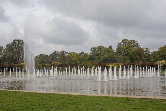 autumn city park with a fountain near the Centennial Hall, a pergola twined with grapes in the background - Powered by Adobe