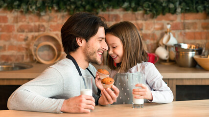 Father And Daughter Having Muffins For Breakfast, Enjoying Homemade Pastry In Kitchen Together And Drinking Milk, Eating Tasty Snacks For Lunch, Baking At Home, Touching Foreheads, Free Space