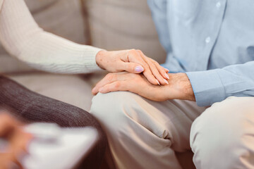 Psychotherapy. Close up of unrecognizable mature couple holding hands, caring elderly woman comforting her husband