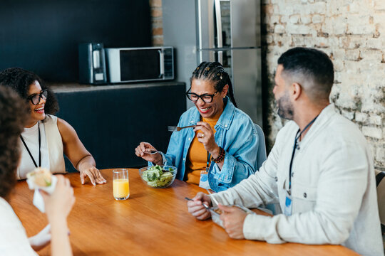 Colleagues enjoying a lighthearted lunch break together with healthy food choices