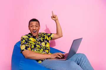 Photo of pretty young male sit bean bag netbook point up eureka wear trendy tropical print outfit...