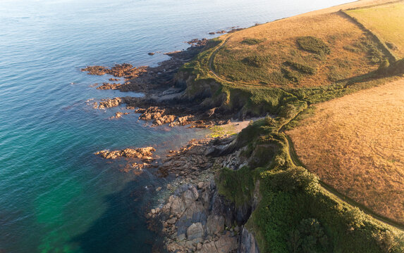 Aerial view of Combe Haven beach with beautiful cliffs and tranquil ocean, Fowey, United Kingdom.