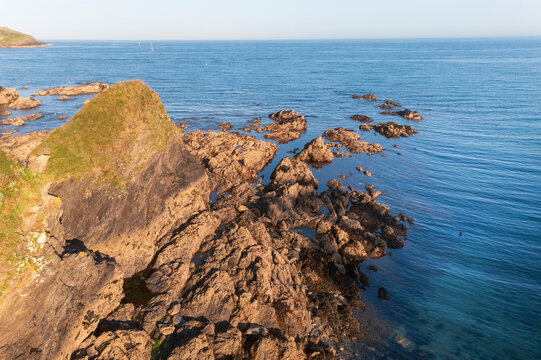 Aerial view of combe haven beach with a swimmer and rocky shore, fowey, united kingdom.