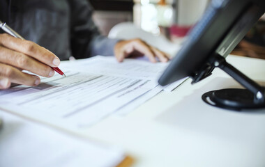 Businessman working in office holding pen verify the accuracy of financial report and business...