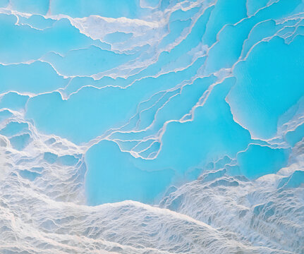 Aerial view of white cotton castle terraces with turquoise water, Pamukkale, Turkey.