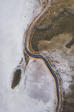 Aerial view of a beautiful salt farm with winding roads in a serene landscape, Dazkiri, Turkey.
