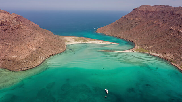 Aerial view of breathtaking turquoise beach and clear water cove with rocky cliffs, Isla Espiritu Santo, Baja California Sur, Mexico.