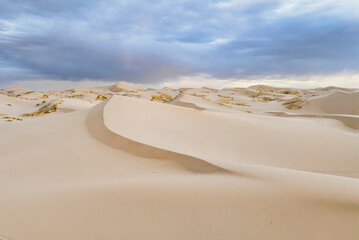 Aerial view of samalayuca dunes under a cloudy sky with expansive sand dunes, Ciudad Juarez, Mexico.