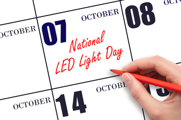 October 7. Hand writing text National LED Light Day on calendar date. Save the date.