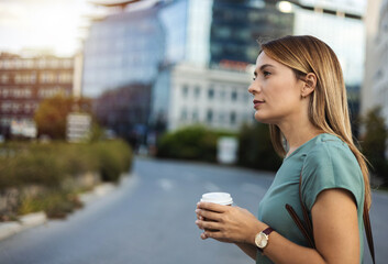 Happy Caucasian woman with takeaway coffee.