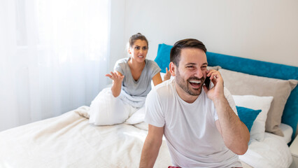 Couple in a Humorous Argument While Sitting on the Bed