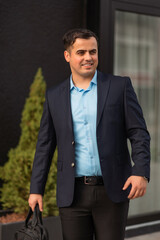 A young happy business man walking in the city street.