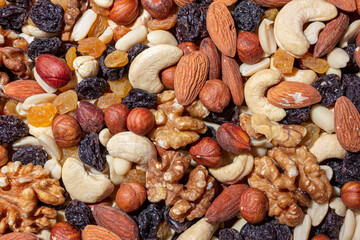 Mixed Nuts: Almonds, Walnuts, Cashews, Peanuts, Hazelnuts, Dried Prunes and Raisins. Different Nut Mix. Background from Various Nuts and Dried Fruits