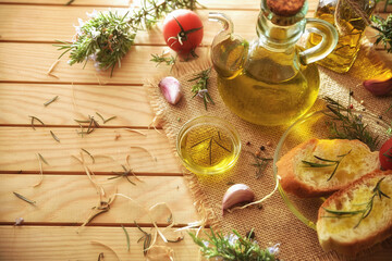 Wooden table with containers with rosemary-essential oil and condiments