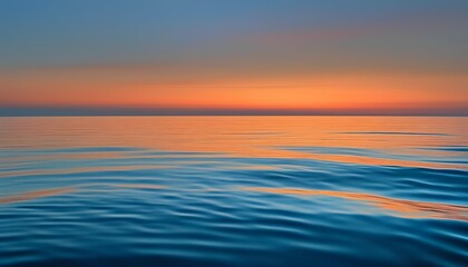 Calm Ocean at Twilight with Soft Orange and Blue Sky Reflections on the Water