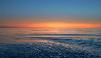 Calm Ocean at Twilight with Soft Orange and Blue Sky Reflections on the Water