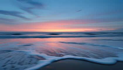 Obraz premium Empty Beach at Twilight with Gentle Waves Rolling Onto the Shore and a Pastel Sky