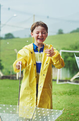 Laugh, rain and boy with umbrella, wet and weather with cover, happiness and cheerful. Humor,...