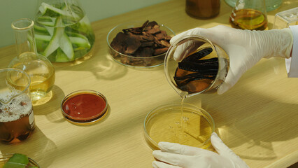 Creative template photo for shampoo advertisement, a black locust extract beaker poured into a petri dish on wooden table top by a researcher. Close up shot from high angle view, displaying space