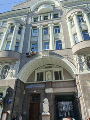 Obraz premium multi-story pink building with ornate details and air conditioning units attached to its windows. The image illustrates the blend of traditional architectural design with modern functionality in urban