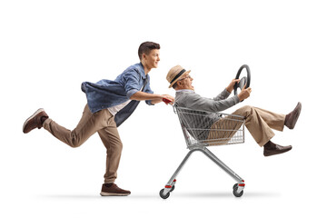 Teenager grandson and grandfather having fun and riding in a shopping cart