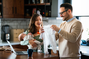 Family, adoption, baby, parenthood and people concept. Happy mother father with newborn baby at home